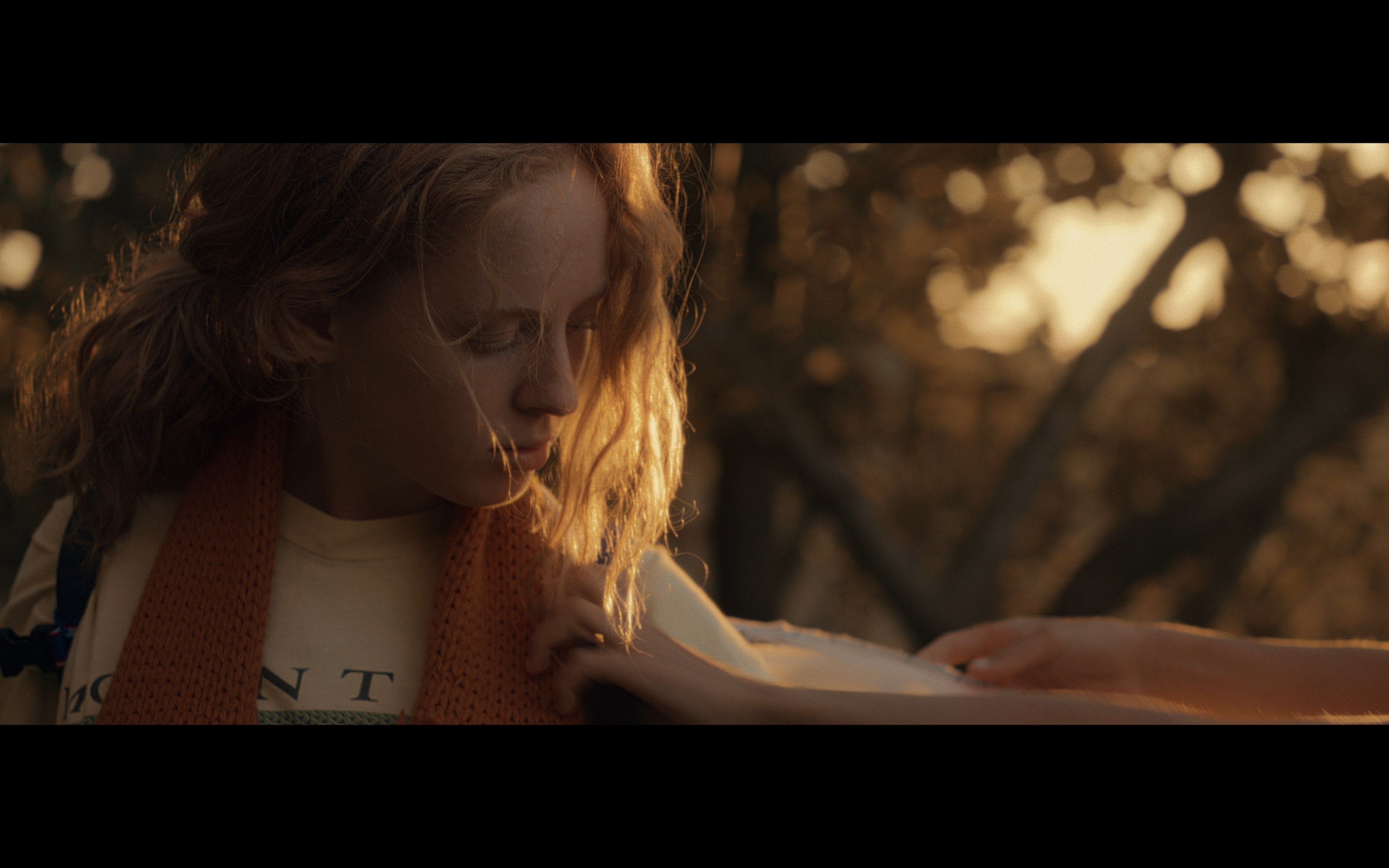 A girl reaching forward in golden evening light