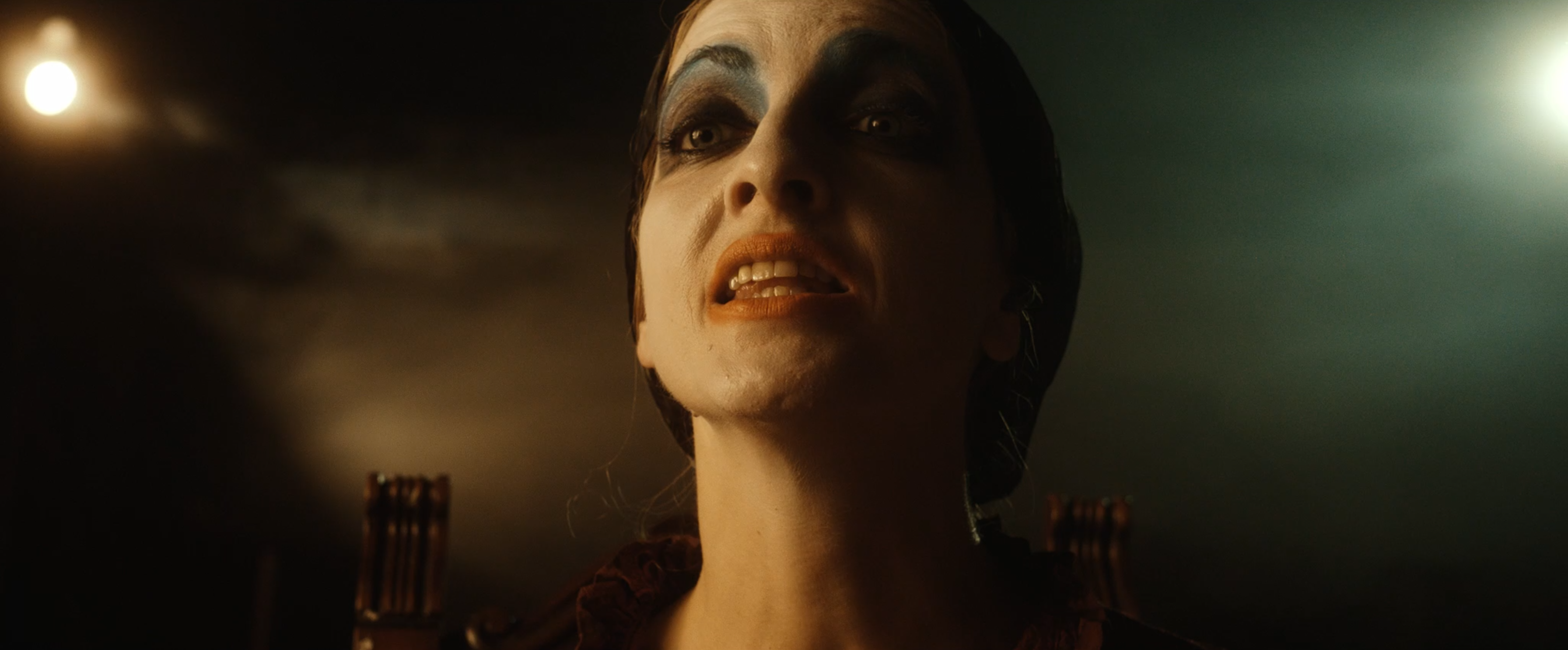 A performer in theatrical makeup in warm light