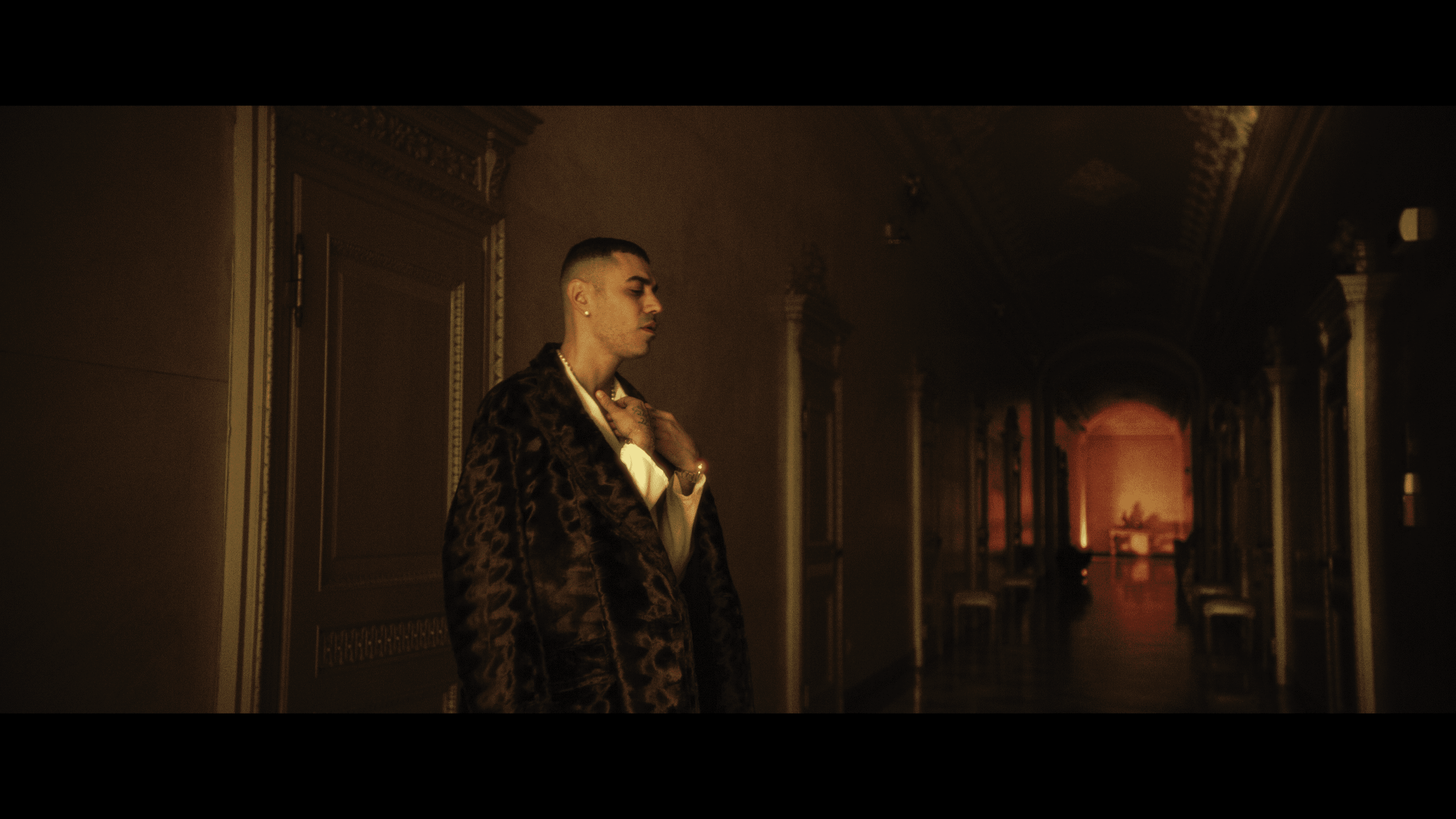 An artist standing in a richly decorated room