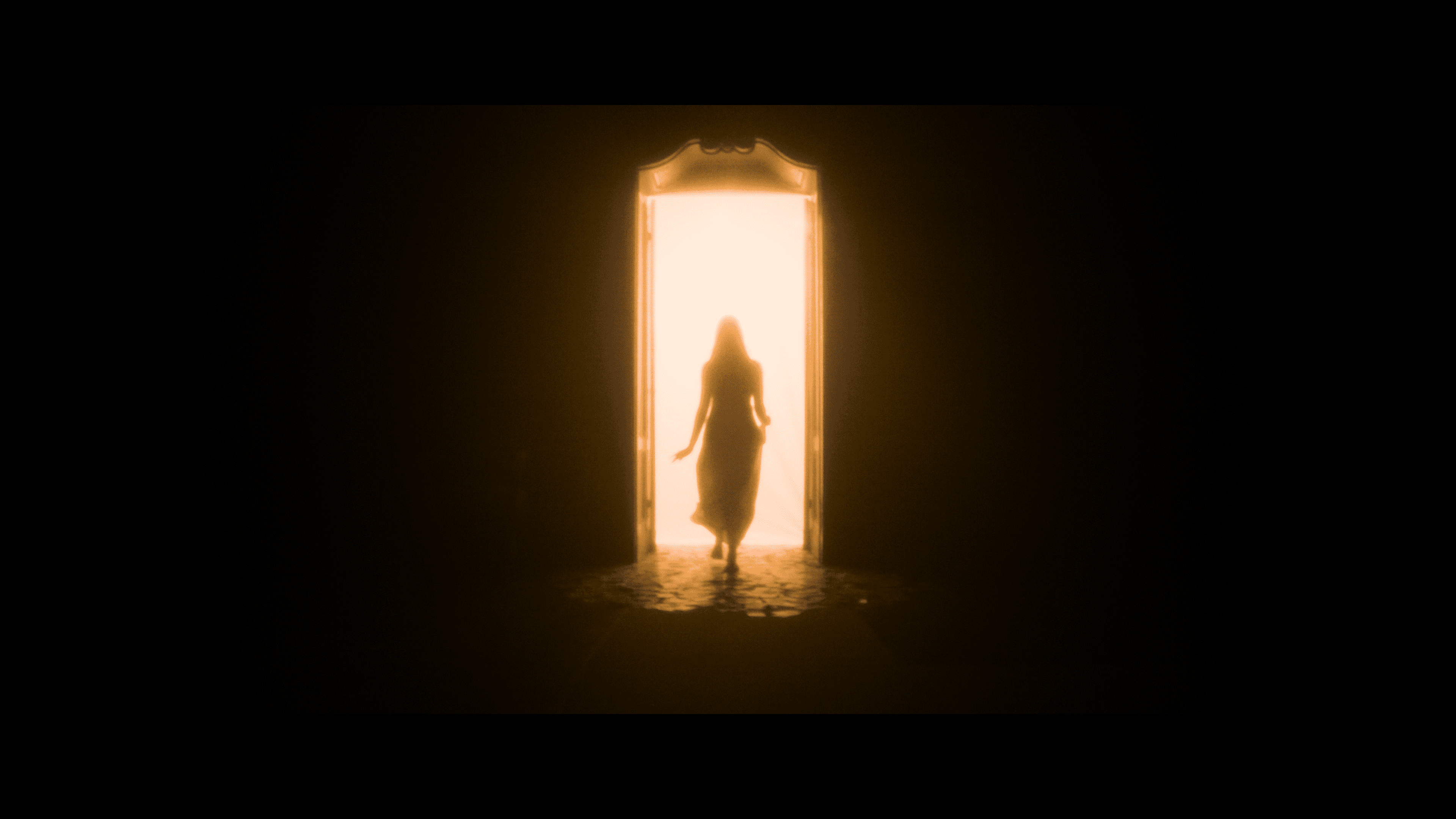 A silhouette emerging through a bright doorway