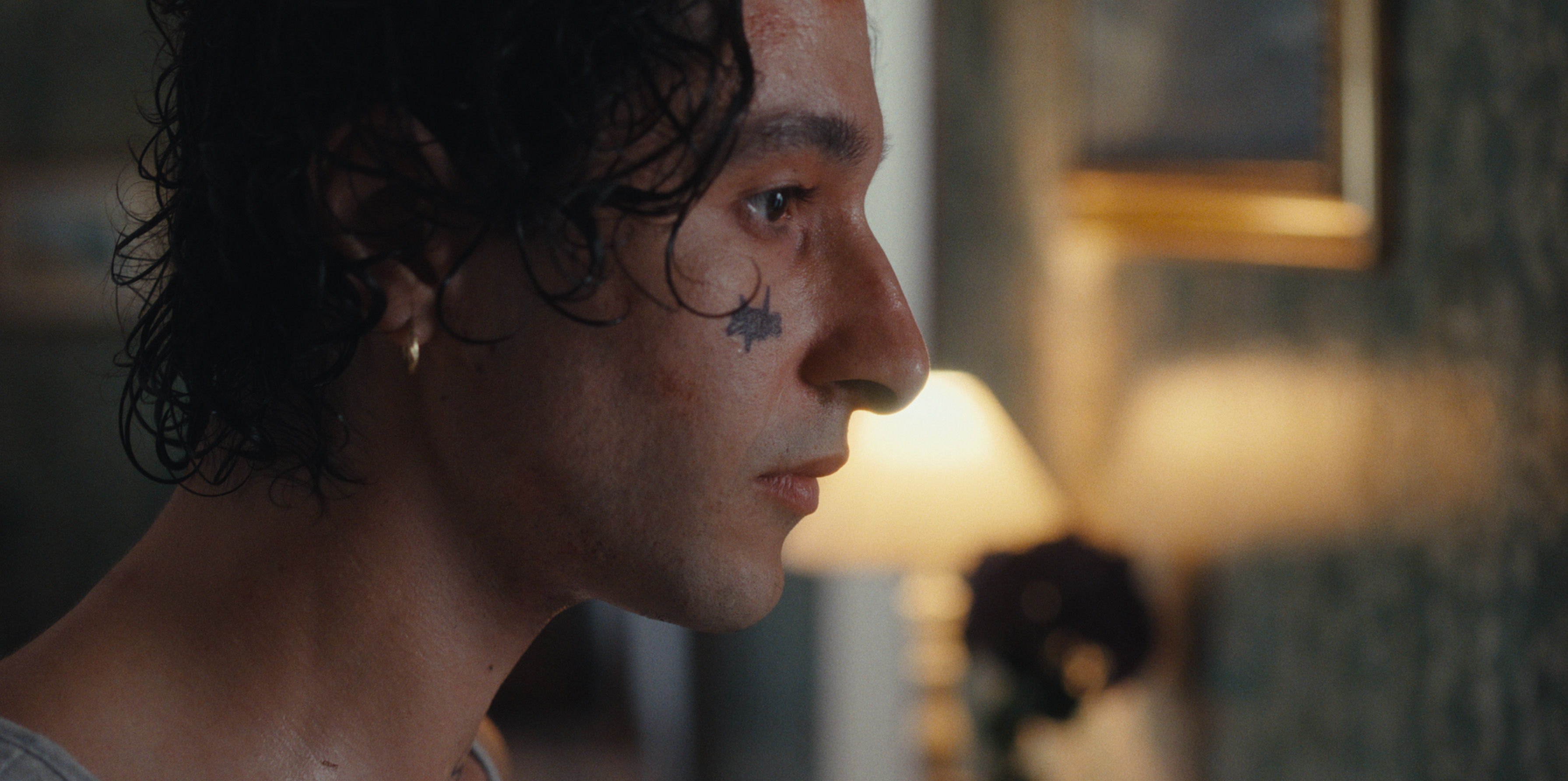 A profile portrait of a man in warm interior light
