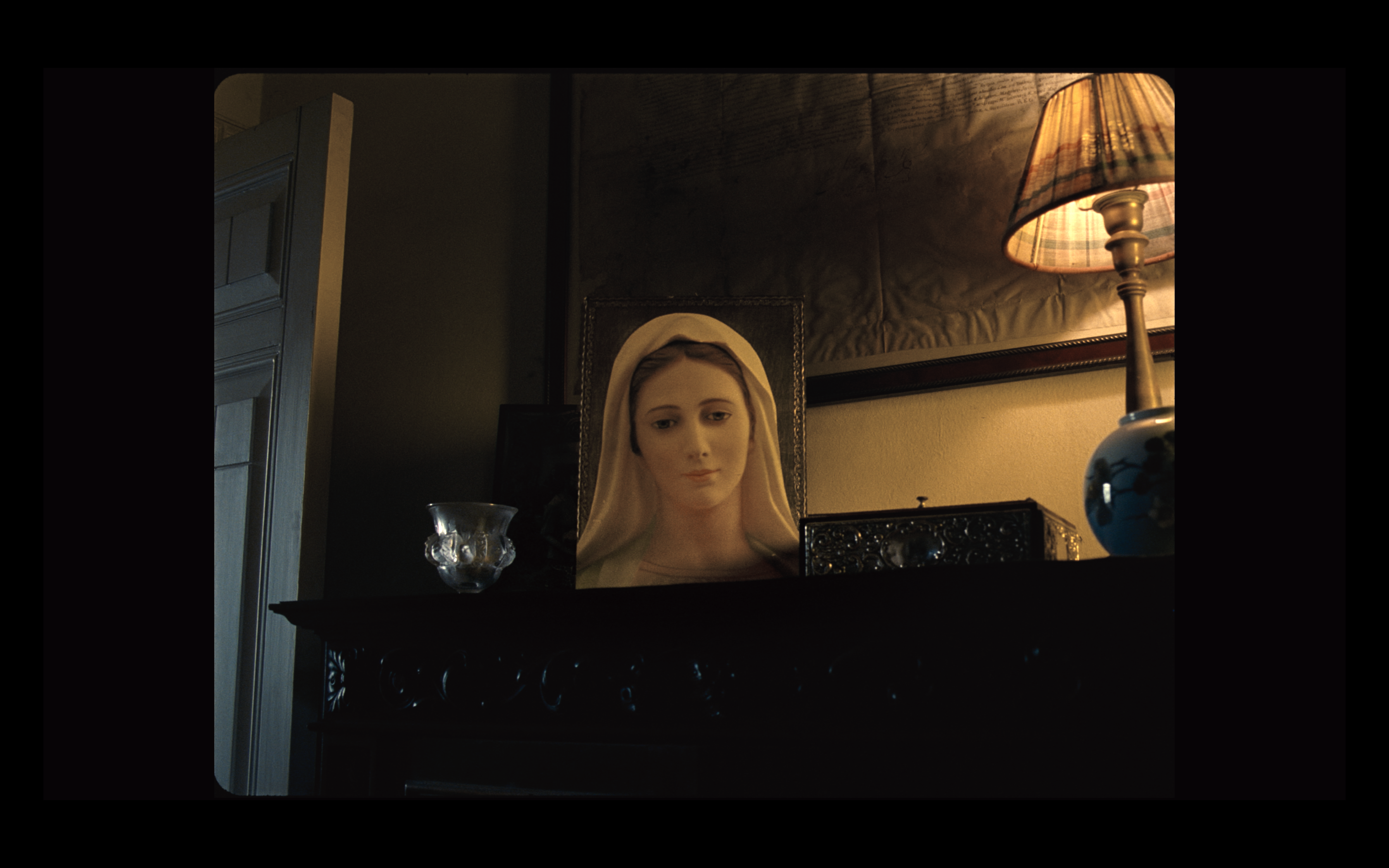 A religious portrait beside a warm table lamp