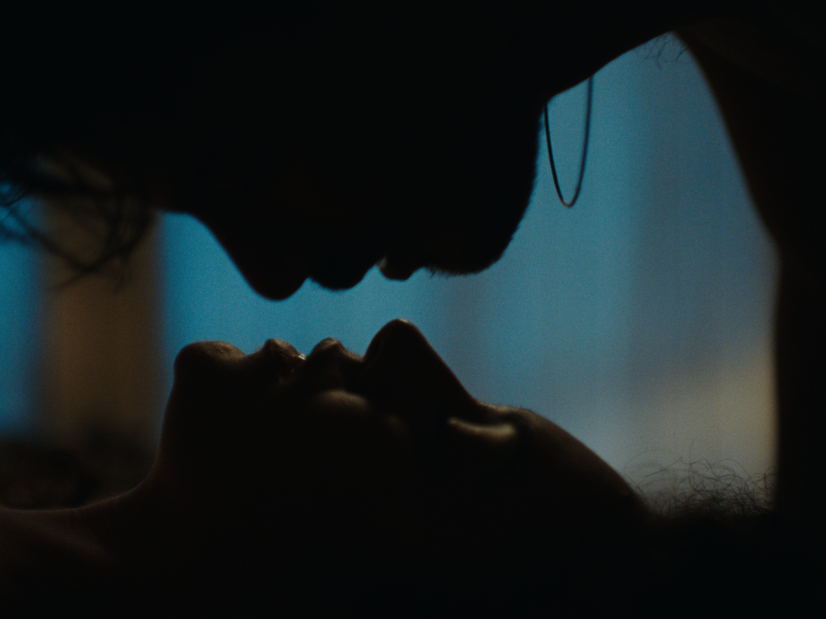 Two faces in silhouette against blue light