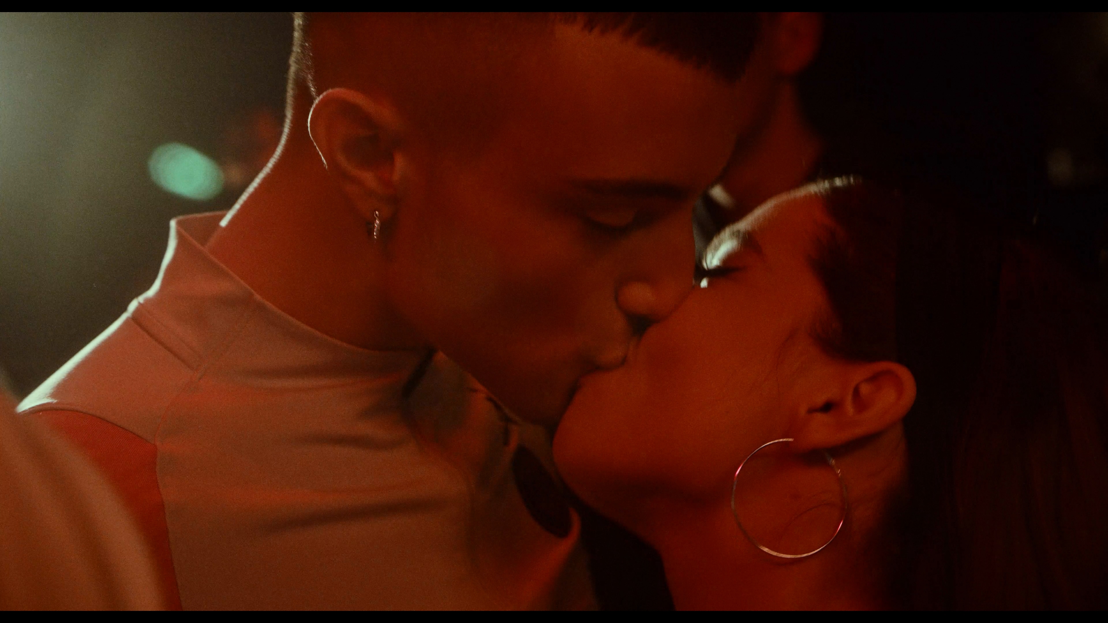 A couple kissing in warm red light
