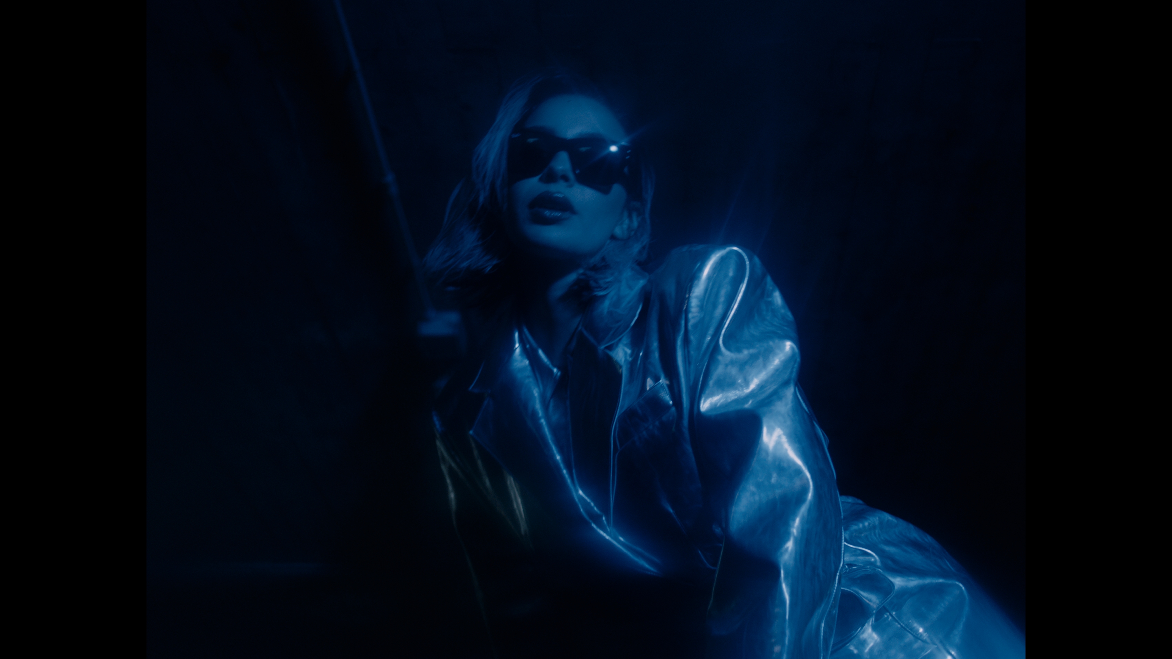 A woman wearing sunglasses in blue light